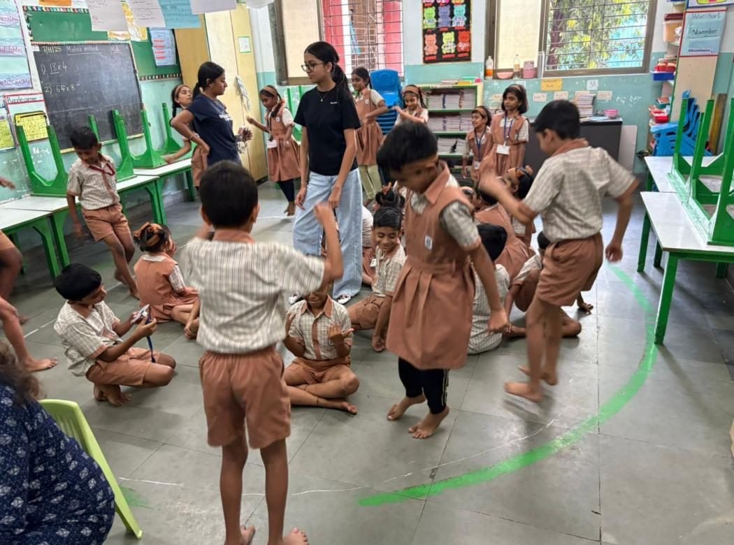Ariana leading an activity with a class of primary-school children