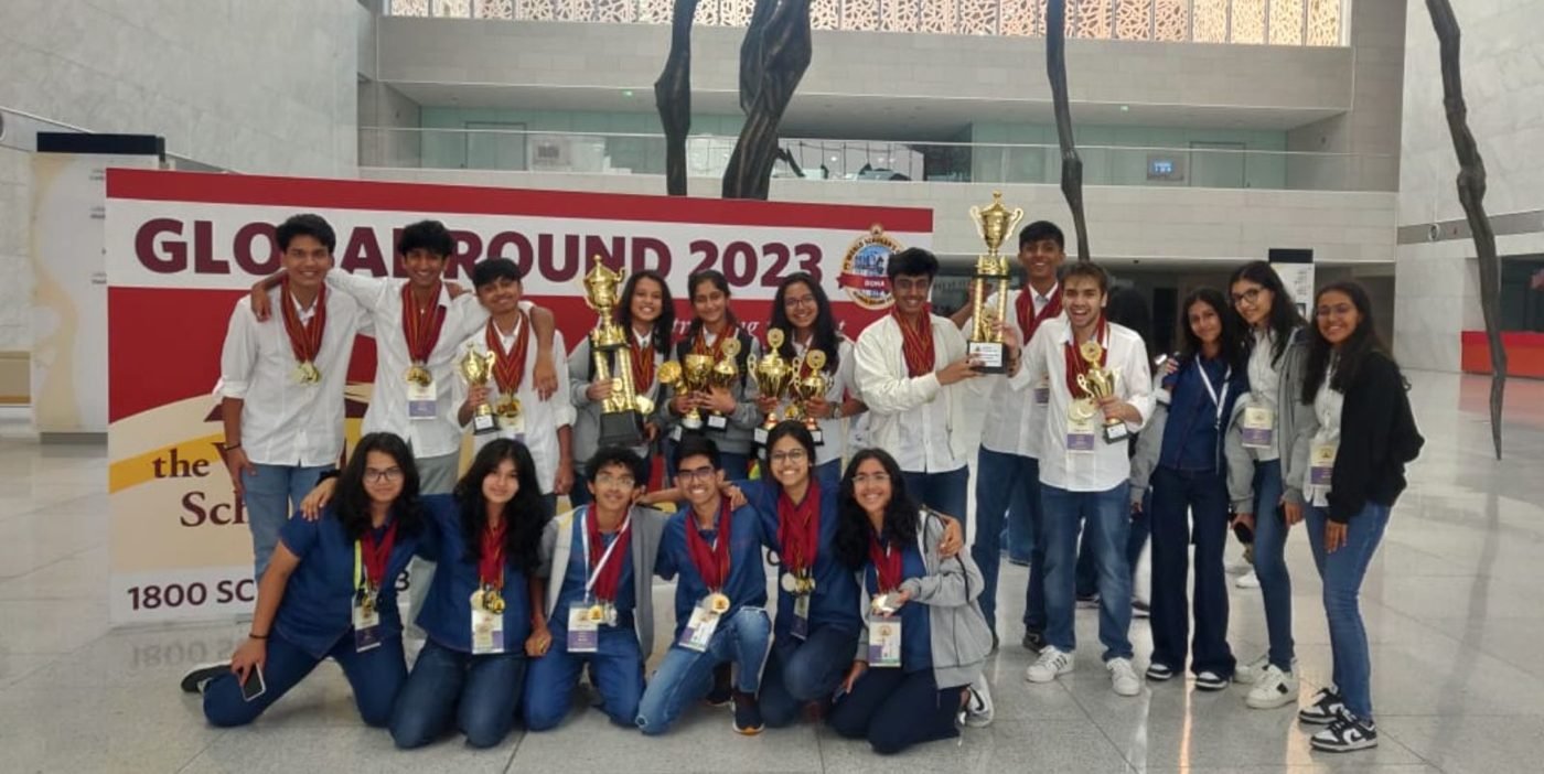 Team with medals in front of a Global Round 2023 banner