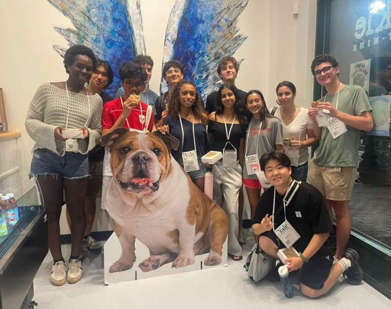 A group of students posing around a cardboard cut-out of the Yale bulldog mascot